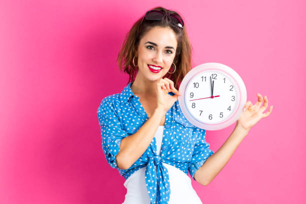 istock Woman holding clock showing nearly 12 909336396