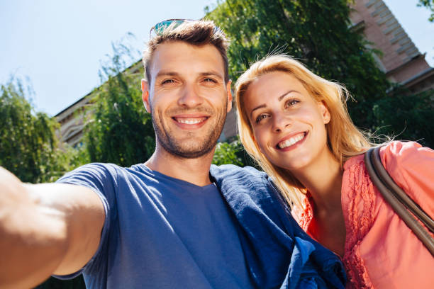 istock Young couple take selfie in park 909337086