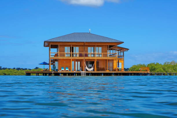 Wooden tropical home over water of Caribbean sea Wooden tropical home on stilts over water of the Caribbean sea, Panama, Central America stilt house stock pictures, royalty-free photos & images