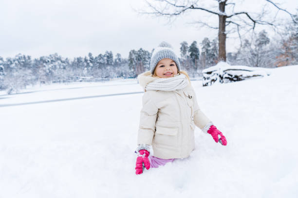istock kid smiling at camera while playing and kneeling in show 909343098