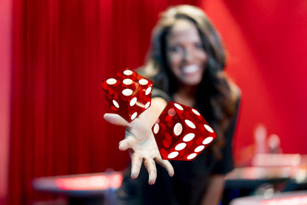 Woman throwing the dice at the casino Happy woman throwing the dice while playing at the casino - lifestyle concepts dice photos stock pictures, royalty-free photos & images