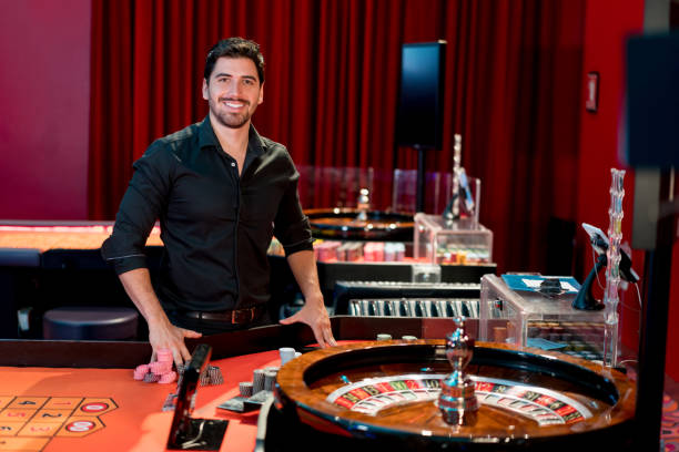 Portrait of a happy man playing roulette at the casino and looking at the camera smiling - lifestyle concepts