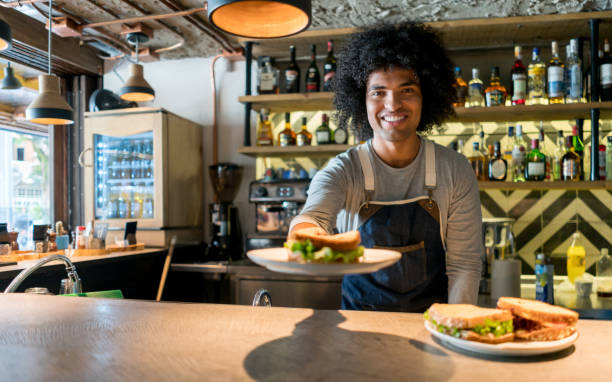istock Happy waiter working at a restaurant 909349402