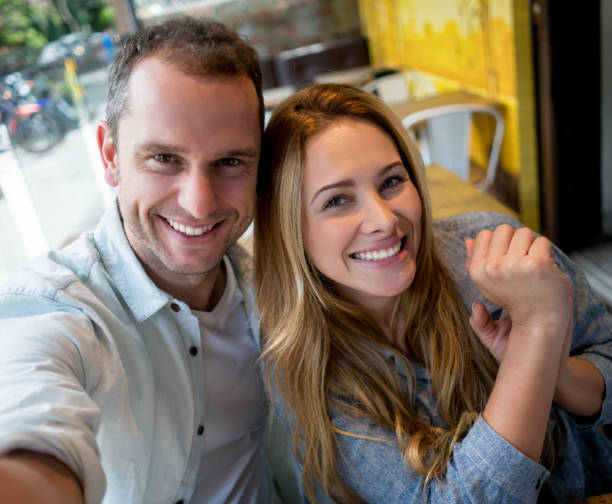 istock Happy couple taking a selfie at a restaurant 909349500