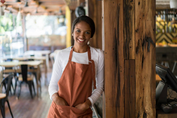 istock Happy woman working at a restaurant 909349552