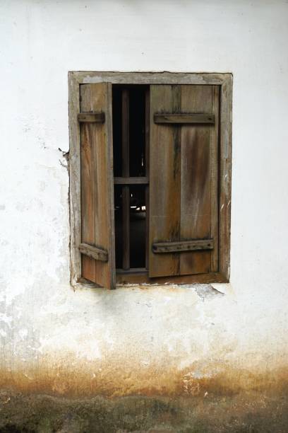 istock Rustic wooden window set in a white stucco wall 909357408