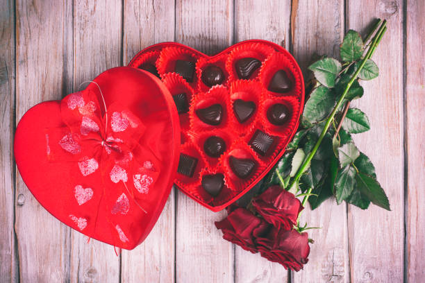istock Heart chocolate box and red roses on wooden rustic background 909357462