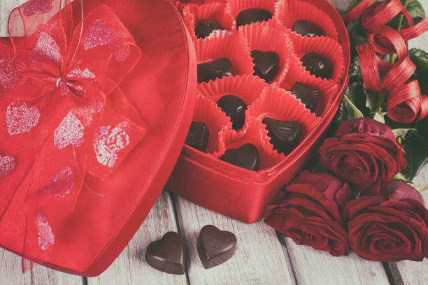 istock Heart chocolate box and red roses on wooden rustic background 909360240