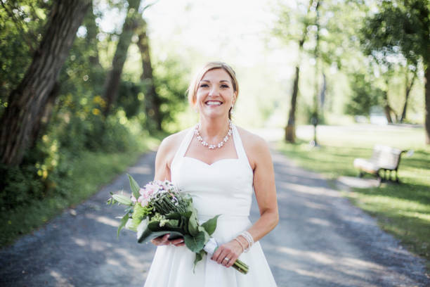 istock Beautiful and happy bride in a parc 909364112