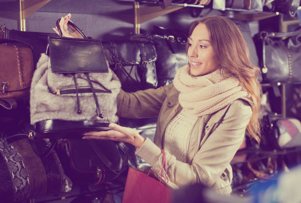 istock Positive girl choosing bag among assortment 909364270
