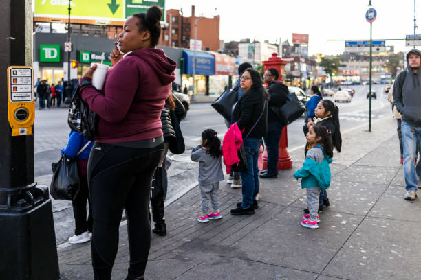 familia de personas espera cruzar la calle en alturas de fordham center, new york city, nyc de noche - familia de cruzar la calle fotografías e imágenes de stock