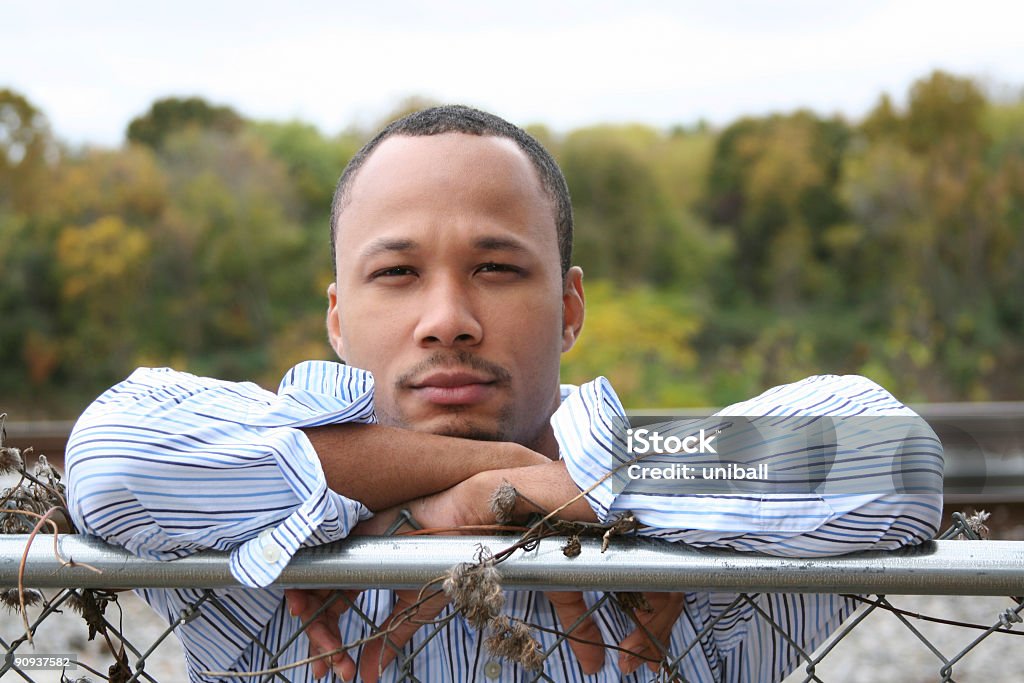 young black man s'inclina sobre valla - Foto de stock de Adulto libre de derechos