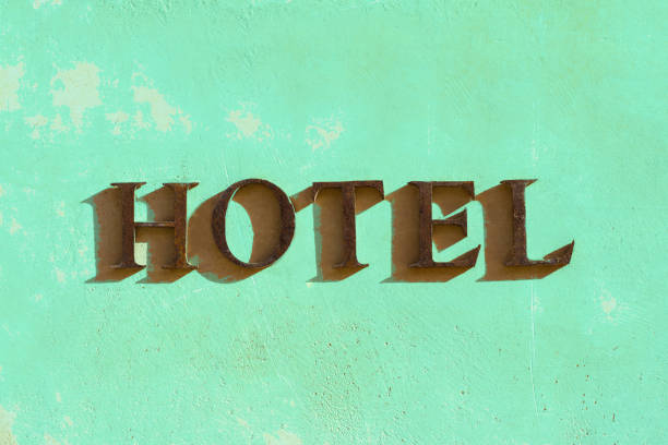 Europe: HOTEL Sign on Pretty Sunlit Green Wall. Copy space available. Shot in Italy.