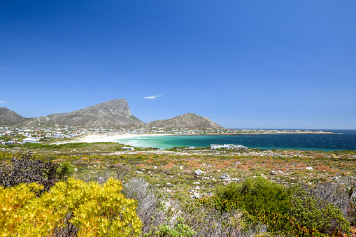 Beautiful view of Pringle Bay, a small beach village located along Route 44 in the eastern part of False Bay near Cape Town. Bushland in the foreground, Hangklip mountain in the background.