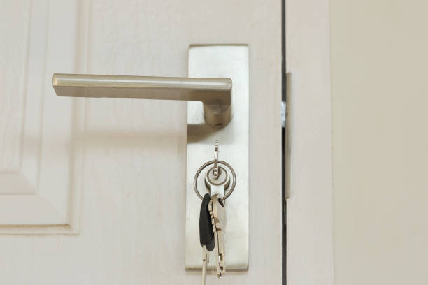 istock Key insert and hold in metallic knob on white door horizontal, architecture by Locksmith 909384928