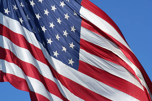 American flag blowing in the wind stock photo