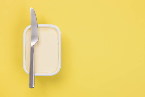 Butter - Isolated Butter and knife on yellow background kitchen knife photos stock pictures, royalty-free photos & images
