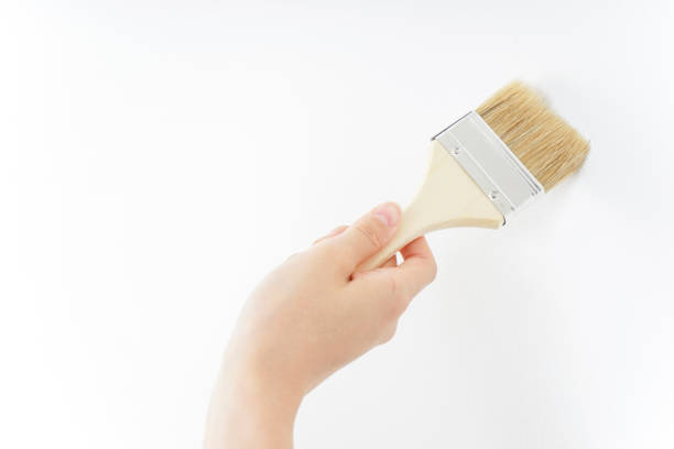istock Woman painting on a wall 909398604