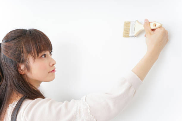 istock Woman painting on a wall 909398634
