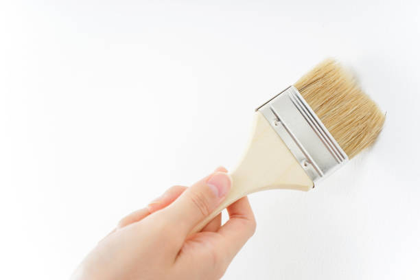 istock Woman painting on a wall 909398646