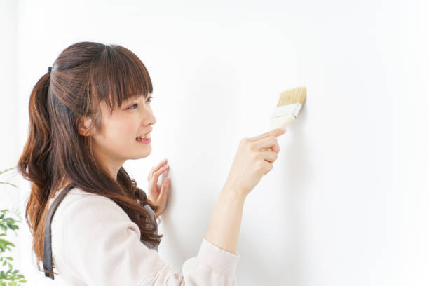 istock Woman painting on a wall 909398656