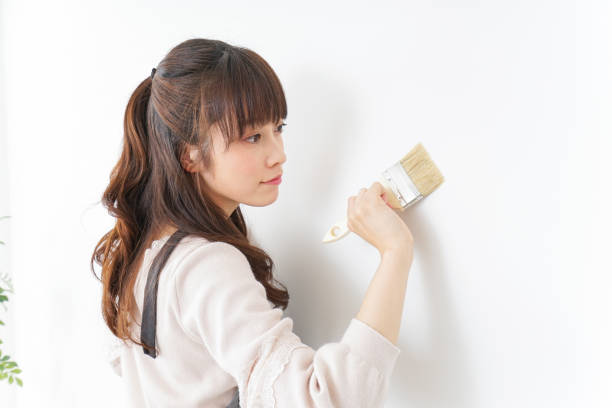 istock Woman painting on a wall 909398662