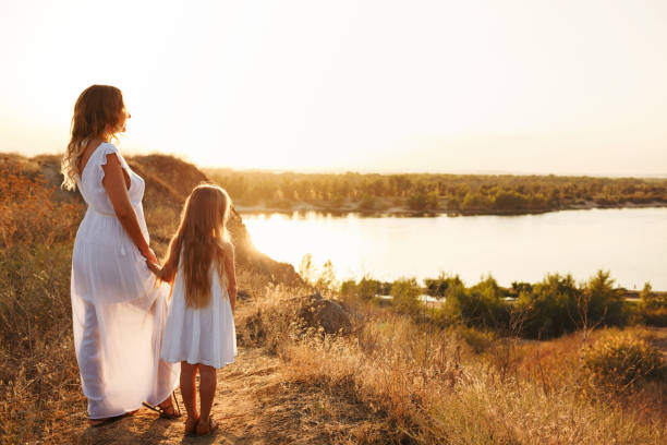 istock Mother and daughter are looking at the river 909399094