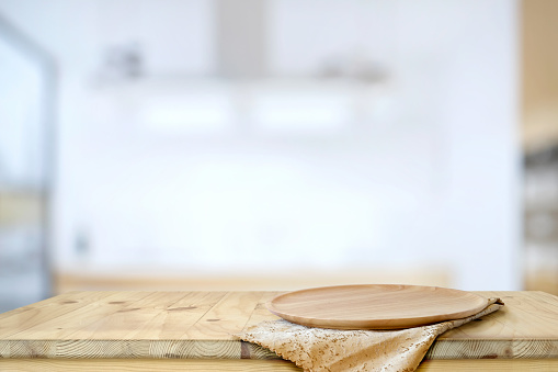 Empty Wood plate on wooded  table with modern kitchen accessories, for food and product display montage