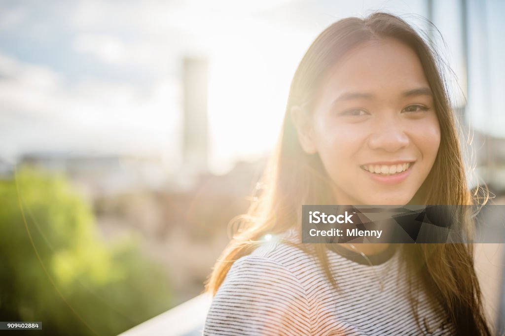 Happy smiling young asian woman looking over Young attractive millennial generation asian woman standing on the Pyrmont Bridge in Darling Harbour looking over with a bright smile. Darling Harbour. Downtown Sydney, New South Wales, Australia Teenage Girls Stock Photo