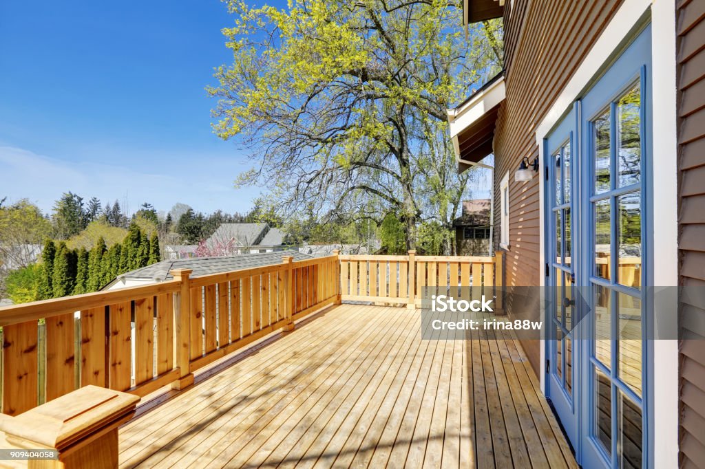 Stately Craftsman home with walkout deck. Spacious sunny walk out deck with nice view. This historic Craftsman home was designed and constructed by Henry Schneider. Deck Stock Photo