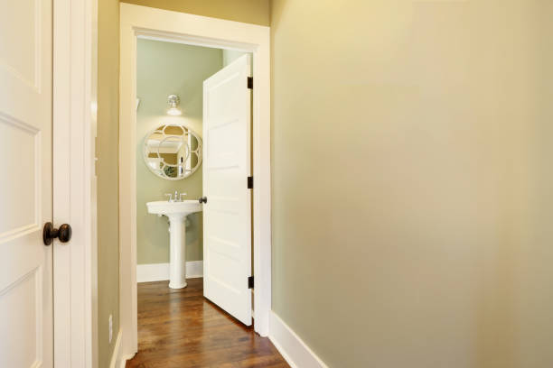 il corridoio verde conduce a un mezzo bagno con un lavabo piedistallo - sink bathroom pedestal tile foto e immagini stock