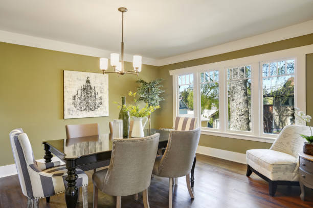 istock Light olive dining room features a wood carved dining table. 909404420