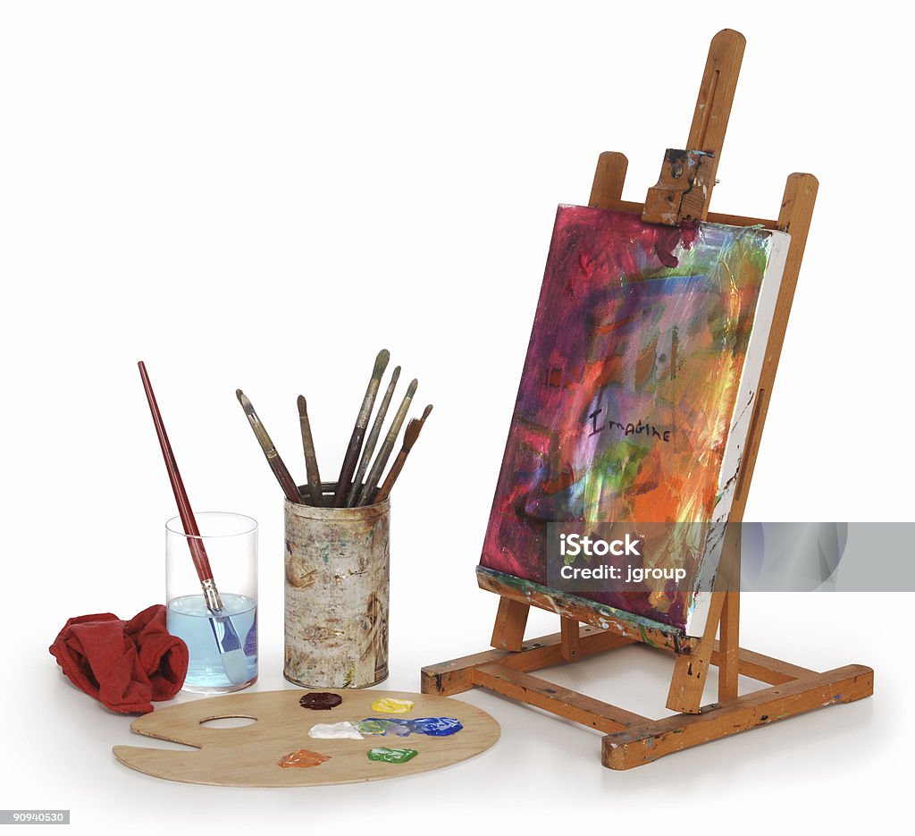 Painted desktop canvas with painting materials painting on canvas, art palette, brushes and easel isolated on white background. Easel Stock Photo