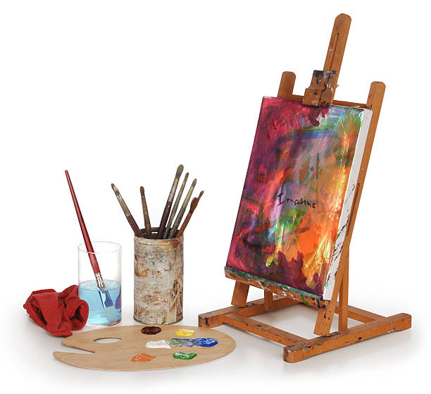 Painted desktop canvas with painting materials painting on canvas, art palette, brushes and easel isolated on white background. easel stock pictures, royalty-free photos & images