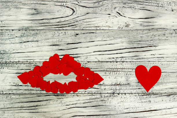 Lips of little red hearts on a wooden background. The concept of Valentine's Day. Lips of little red hearts on a wooden background. The concept of Valentine's Day. knitting textile wool infinity stock pictures, royalty-free photos & images