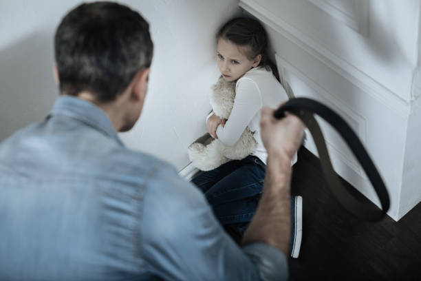 Scared girl sitting in the corner with teddy bear