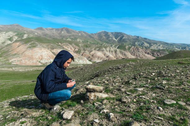 istock A traveler in the mountains, a compass orientation 909412046