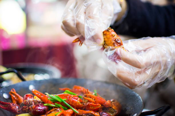 istock Hands with plastic gloves taking crayfish from spicy crayfish po 909419824