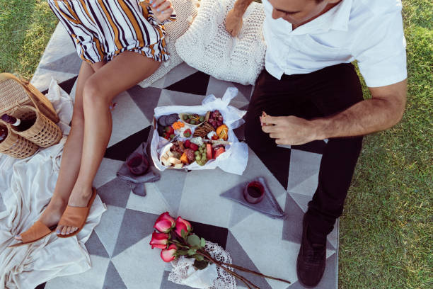 istock Romantic couple having a picnic at sunset 909420468