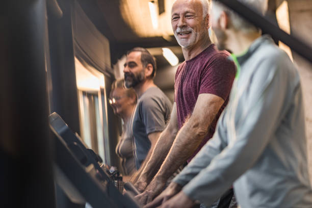 istock Group of happy active seniors talking while exercising in a gym. 909422836
