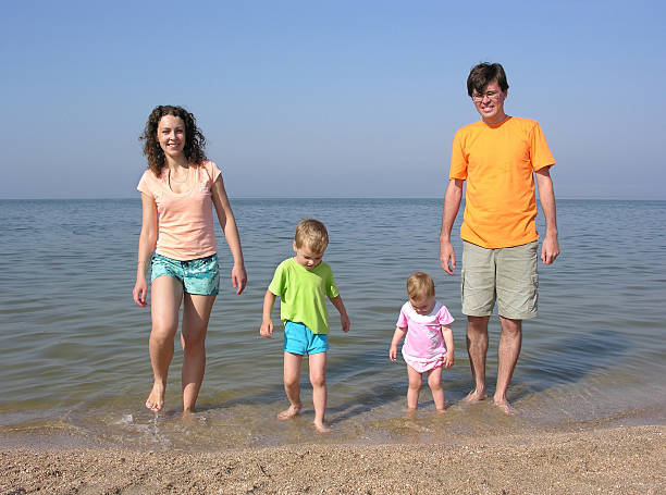 família de quatro na praia - four animals four objects four people cleanup - fotografias e filmes do acervo