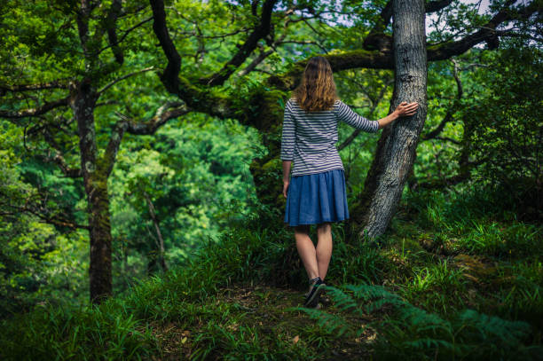 istock Young woman walking in the woods 909424376