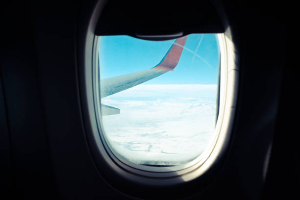 istock Close up Airplane window with airplane wing 909427350