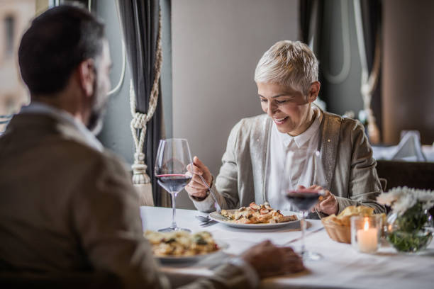 istock Happy mature couple having lunch in a restaurant. 909430742