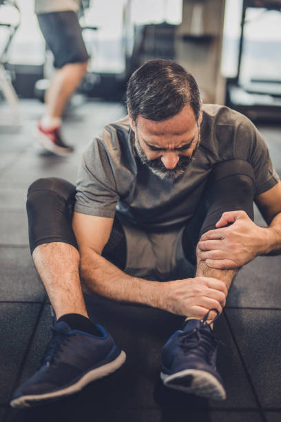 istock Active mature man feeling pain in his leg in a gym. 909432748