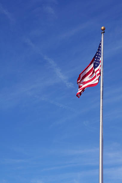 istock American Flag waving with a blue sky backdrop 90943658