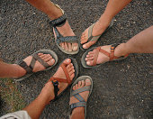 Many different feet and sandals form a circle