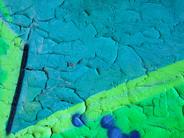 Blue-green graffitti close-up with cracking paint stock photo