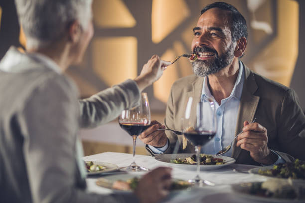 istock Happy mature couple having fun during dinner time in a restaurant. 909437248