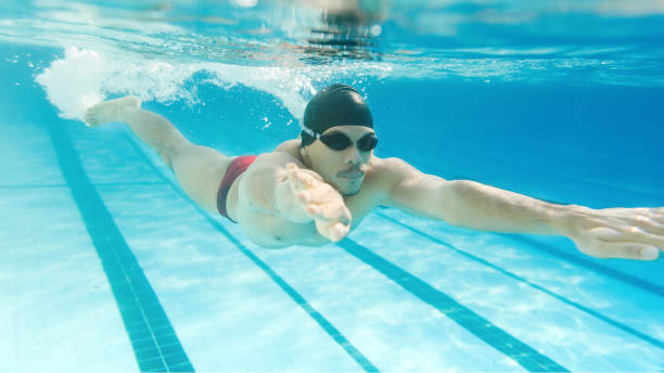 istock asian man swimming under the water 909439968